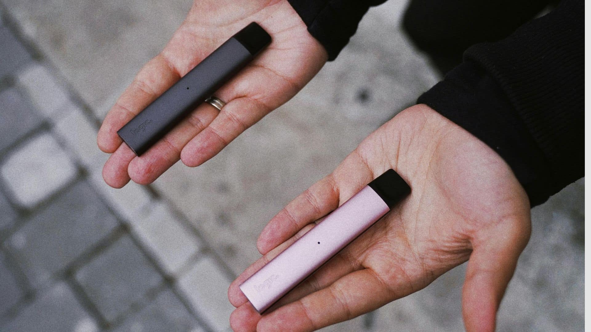 Hands holding vapes with different colours