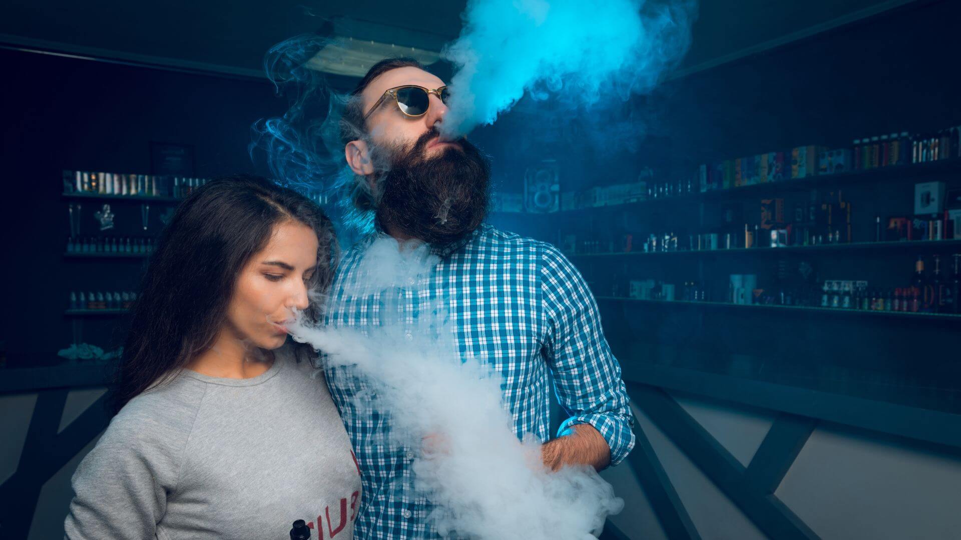 Customers enjoying disposable vapes at CLICKY Malaysia vape shop with vapor clouds in the background.